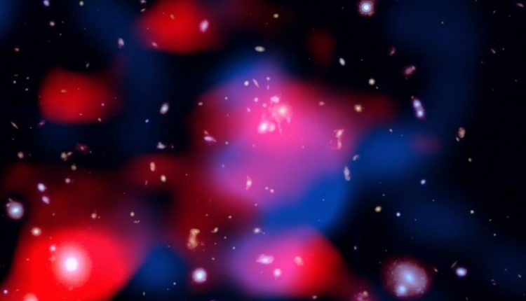 This stunning image reveals a distant galaxy cluster teeming with energy: galaxies shine in visible light (white), ghostly red clouds unveil a newly discovered radio mini-halo—the most distant ever detected—and blue wisps trace the hot gas glowing in X-rays. Credit: X-ray: NASA/CXC/SAO; Optical: NASA/ESA/STScI; Radio: ASTRON/LOFAR; Image Processing: NASA/CXC/SAO/N. Wolk