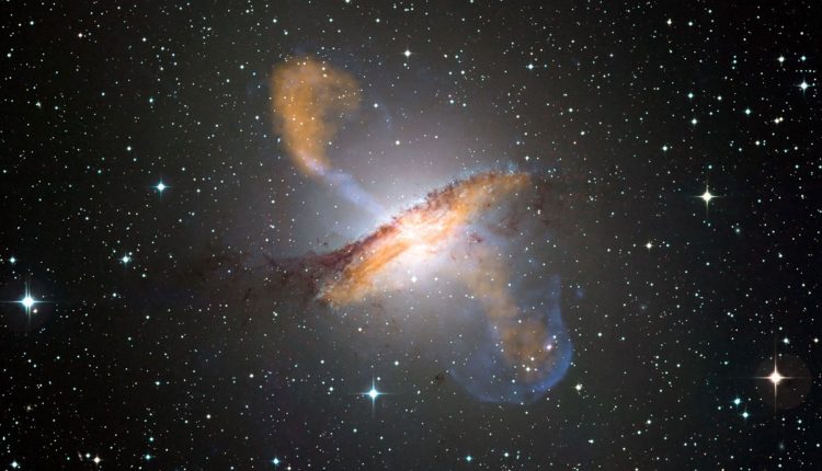 Centaurus A is a famous example of a relatively nearby radio galaxy. Inside the galaxy is a supermassive black hole, which generates the large jets that can be seen emerging perpendicular to the disc of the galaxy. Credit: NASA/ESO/WFI/MPIfR/APEX/CXC/CfA/A.Weiss et al.